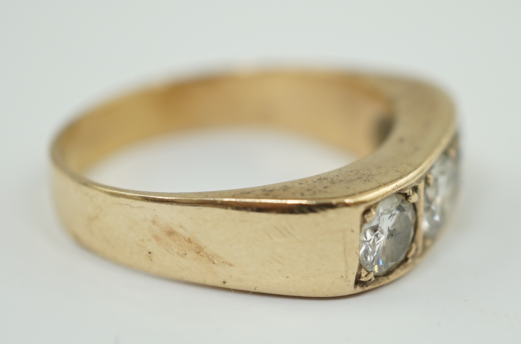 A gold and channel set three stone diamond ring